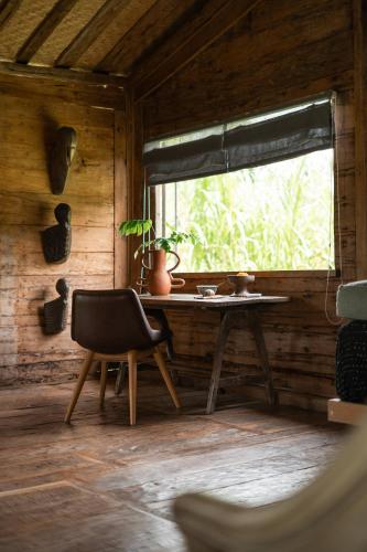 a table and a chair in a room with a window at Desa Seni Baturiti in Baturiti