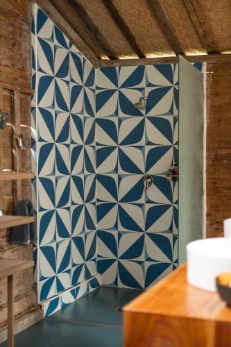 a bathroom with a blue and white tile wall at Desa Seni Baturiti in Baturiti