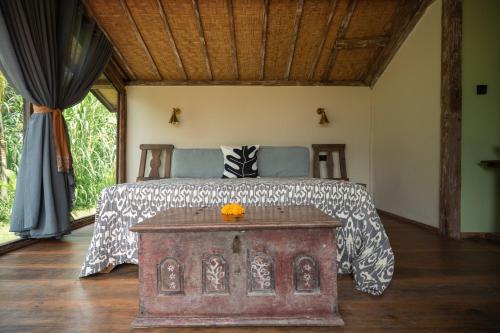 a bedroom with a bed with a table in it at Desa Seni Baturiti in Baturiti
