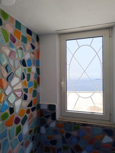 a window in a room with a view of the ocean at Love in Blue - La Terrazza di Positano in Positano