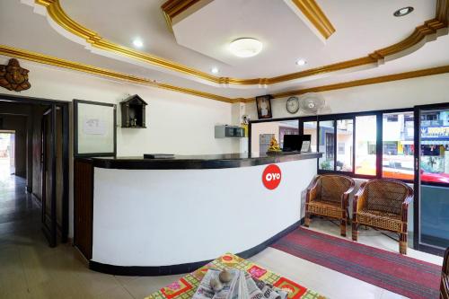 a lobby with a counter and chairs in a building at Hotel O Lekshmi Rooms & Villas in Alleppey