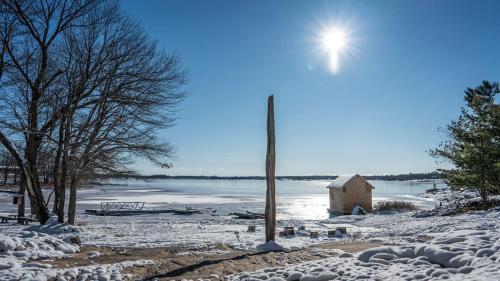 a snow covered beach with a light pole and a body of water at Georgian Bay 3-bdrm lakefront Main House in Dillon