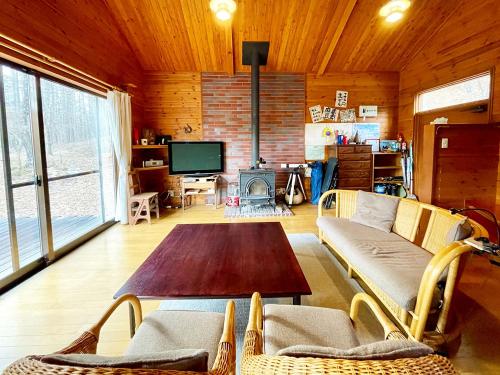 YanaikeにあるYatsugatake Mountain Cabin - 八ヶ岳 お山の家のソファとテーブルのあるリビングルーム