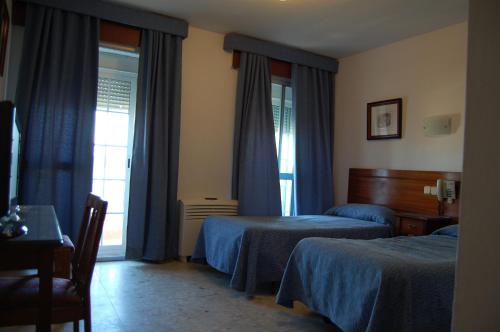 pokój hotelowy z dwoma łóżkami i oknem w obiekcie Hotel Marina Victoria w mieście Algeciras