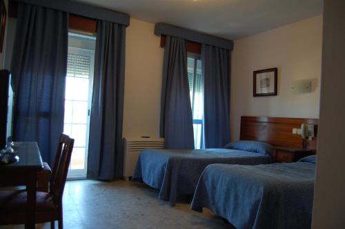 アルヘシラスにあるホテル マリーナ ビクトリアのベッド2台と窓が備わるホテルルームです。