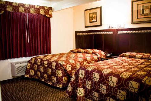 um quarto de hotel com duas camas e uma janela em Whispering Palms Inn em Del Rio