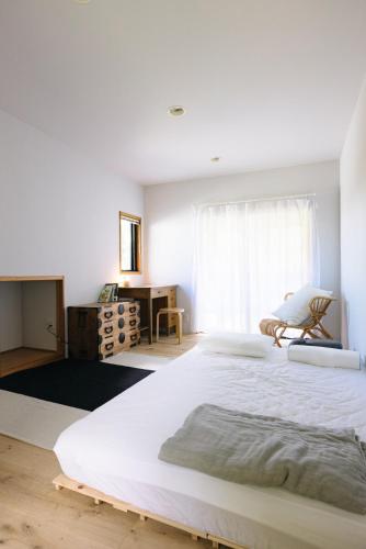 a bedroom with a large white bed and a desk at フォレスト247 in Nagano