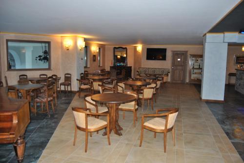 a restaurant with tables and chairs in a room at Casa Vacanza La Rocca in Chiesa in Valmalenco