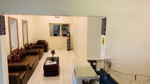 a living room with couches and chairs in a room at Hotel Adya Classsic in Kammasandra