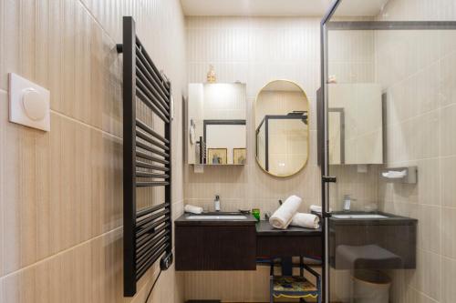 une salle de bain avec un lavabo et un miroir dans l'établissement Élégance et Luxe au Cœur de Bordeaux-Quinconces, à Bordeaux