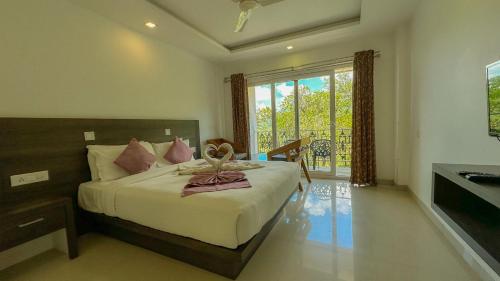 a bedroom with a bed and a large window at The Heights Munnar in Munnar