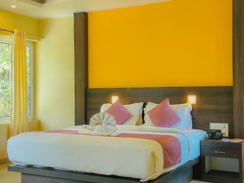 a bedroom with a large bed with pink pillows at The Heights Munnar in Munnar