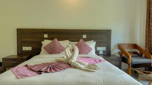 a bed with a stuffed animal on top of it at The Heights Munnar in Munnar