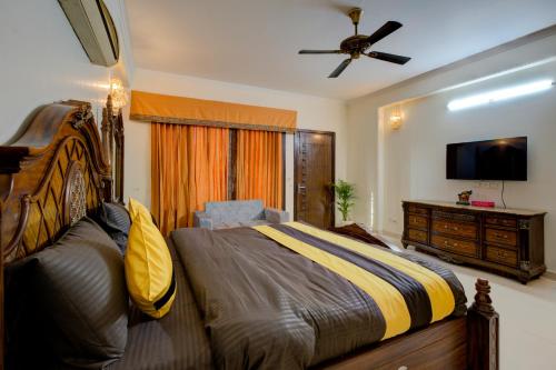 a bedroom with a bed and a dresser and a television at Amrit Hotel - Hotel & Banquet,Sector 32 in Gurgaon