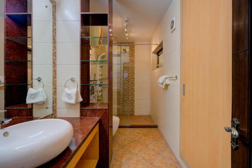 a bathroom with a white sink and a shower at Amrit Hotel - Hotel & Banquet,Sector 32 in Gurgaon