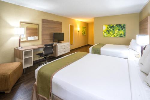 a hotel room with two beds and a desk at Wyndham Garden Washington DC North in Washington