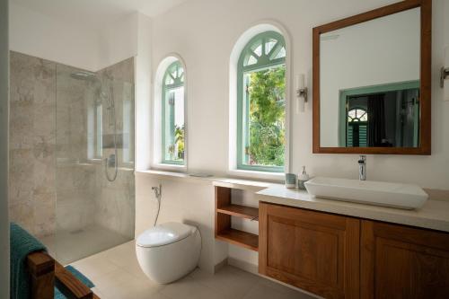 a bathroom with a toilet and a sink and a shower at Kalkudah Beach House in Batticaloa