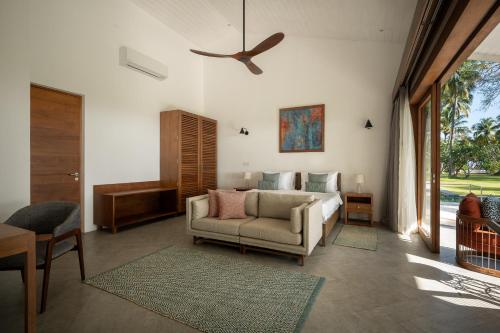 a living room with a couch and a ceiling fan at Kalkudah Beach House in Batticaloa