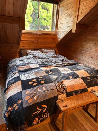 a bedroom with a bed in a log cabin at Rental villa Gontaya in Takamori