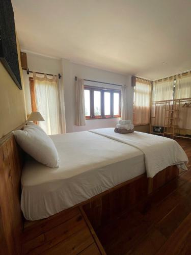 a bedroom with a large white bed with a window at Eco Lagoon in Phu Quoc