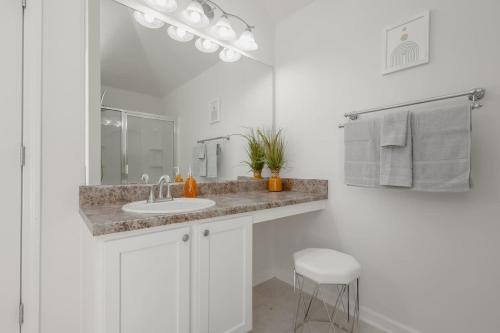 a white bathroom with a sink and a mirror at Large Rustic Family Home By RoadATL-KingBed-Firepit-Grill in Braselton