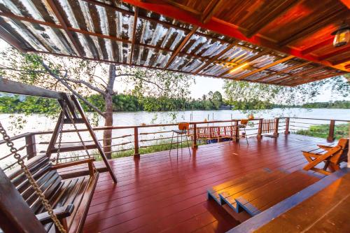 a deck of a boat with chairs and a table at Chuenwaree Riverside Stay in Suratthani