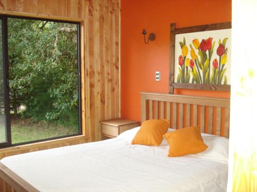 1 dormitorio con cama y ventana grande en Cabañas Rukalafquen, en Licán Ray