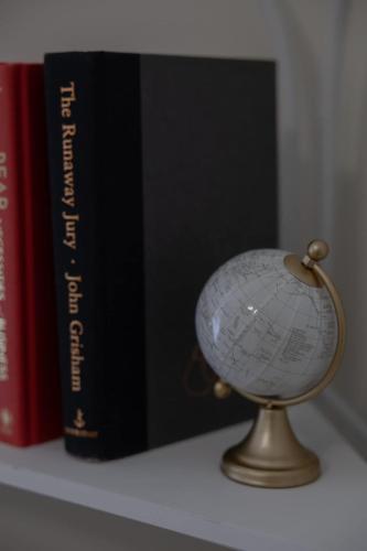 a globe sitting on a shelf next to books at Large Rustic Family Home By RoadATL-KingBed-Firepit-Grill in Braselton