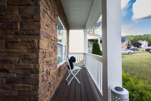 a rocking chair on a porch of a house at Large Rustic Family Home By RoadATL-KingBed-Firepit-Grill in Braselton