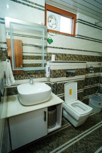 a bathroom with a sink and a toilet at Monal Meadows in Bhīm Tāl