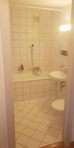 a white tiled bathroom with a shower and a sink at Superbe Studio en Plein Centre à Lausanne Gare in Lausanne