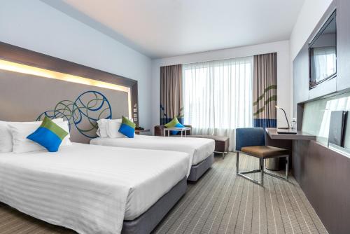 a hotel room with two beds and a television at Four Points by Sheraton Bangkok Ploenchit Sukhumvit in Bangkok
