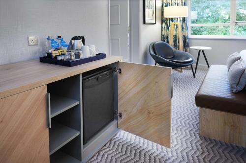 a kitchen with a counter and a chair in a room at Hilton Cobham in Cobham