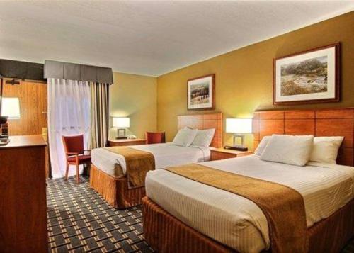 una habitación de hotel con dos camas y una mesa en Quality Inn Thief River Falls, en Thief River Falls