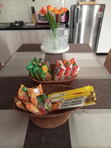 a table with two baskets of snacks and a vase of flowers at Anagata House Batu at C8 Grand Kusuma Hill in Batu