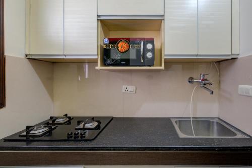 a kitchen with a stove and a microwave at Amrit Hotel - Hotel & Banquet,Sector 32 in Gurgaon