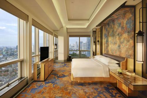 a bedroom with a bed and a large window at Keraton At The Plaza, part of The Unbound Collection by Hyatt in Jakarta