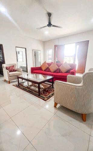 a living room with a red couch and a coffee table at Villa Alyana in Ipoh