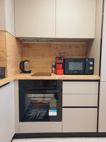 a kitchen with a microwave and a stove at Your Home in Plovdiv with Free Private Parking in Plovdiv