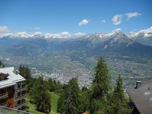 a view of a valley with snow capped mountains at Sunny apartment with outdoor dinning in Veysonnaz