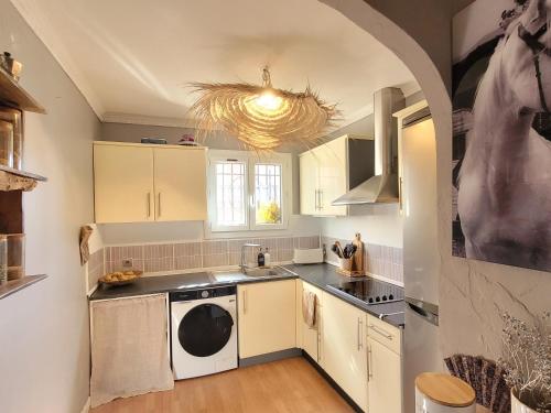 une cuisine avec des armoires blanches et une laveuse et une sécheuse dans l'établissement Vacances cosy au soleil, à Fréjus