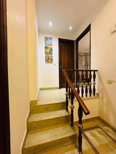 a staircase in a home with wooden floors and a door at Luxury HomeStay Prime Location, South Delhi in New Delhi