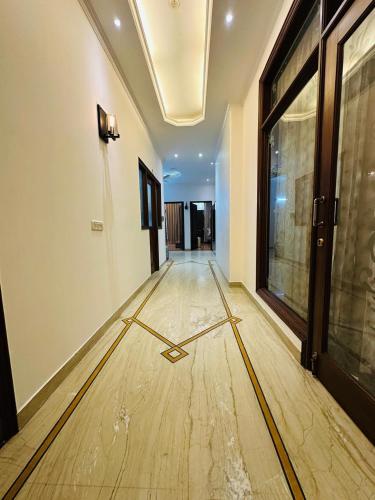 an empty hallway with a wooden floor in a building at Luxury HomeStay Prime Location, South Delhi in New Delhi