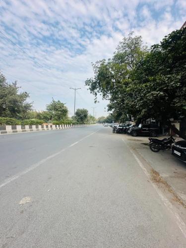an empty street with cars parked on the side of the road at Luxury HomeStay Prime Location, South Delhi in New Delhi