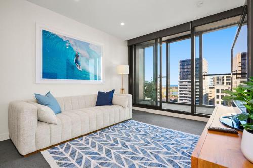 a living room with a couch and large windows at Lumina Bluewater Retreat in Melbourne