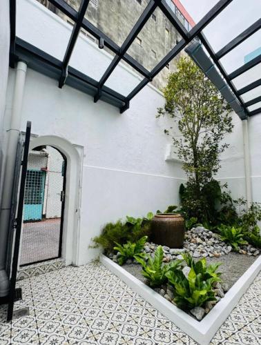 an open door to a patio with a garden at 1917 By MUO in Muar
