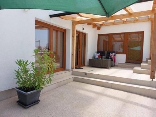 a porch of a house with a green umbrella at Village Premium Apartment by Český Krumlov - adults only in Střížov