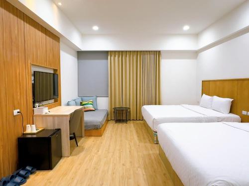 a hotel room with two beds and a television at Sleep jia in Tainan