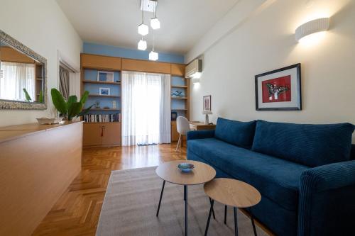 ein Wohnzimmer mit einem blauen Sofa und einem Tisch in der Unterkunft Mari's Apartment in Kalamata