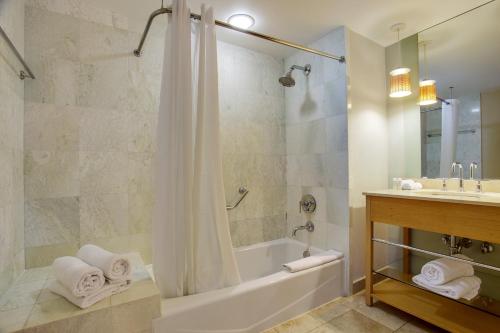 マイアミビーチにあるMarenas Beach Resort Private Luxury Suitesの浴槽、シャワー、洗面台を備えたバスルーム